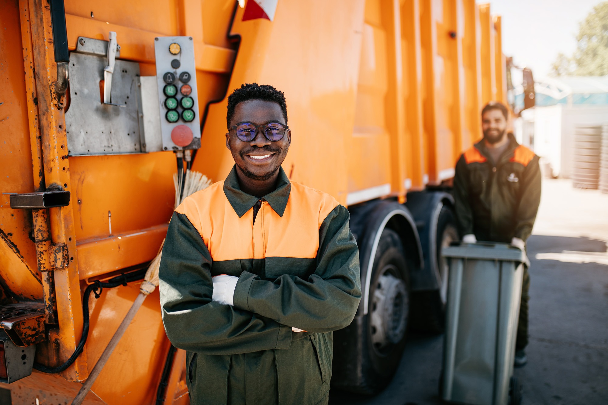 young garbage men working together on emptying dustbins for trash removal