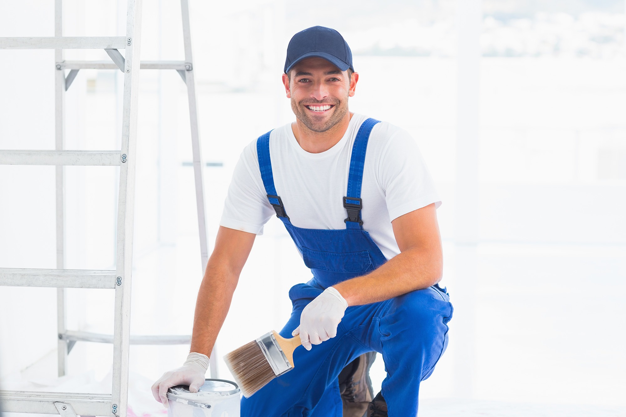 Portrait of smiling handyman with paintbrush and can at home